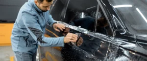 Nano ceramic coating, car protection, scratch resistance, technician applying coating, vehicle durability, Dr Tint services, professional application. Revêtement nano céramique, protection voiture, résistance aux rayures, technicien appliquant un revêtement, durabilité véhicule, services Dr Tint, application professionnelle.