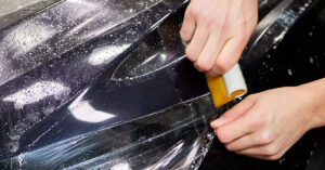 Image qui montre l'installation d'une pellicule pare-pierre. Image showing the installation of a paint protection film (PPF).